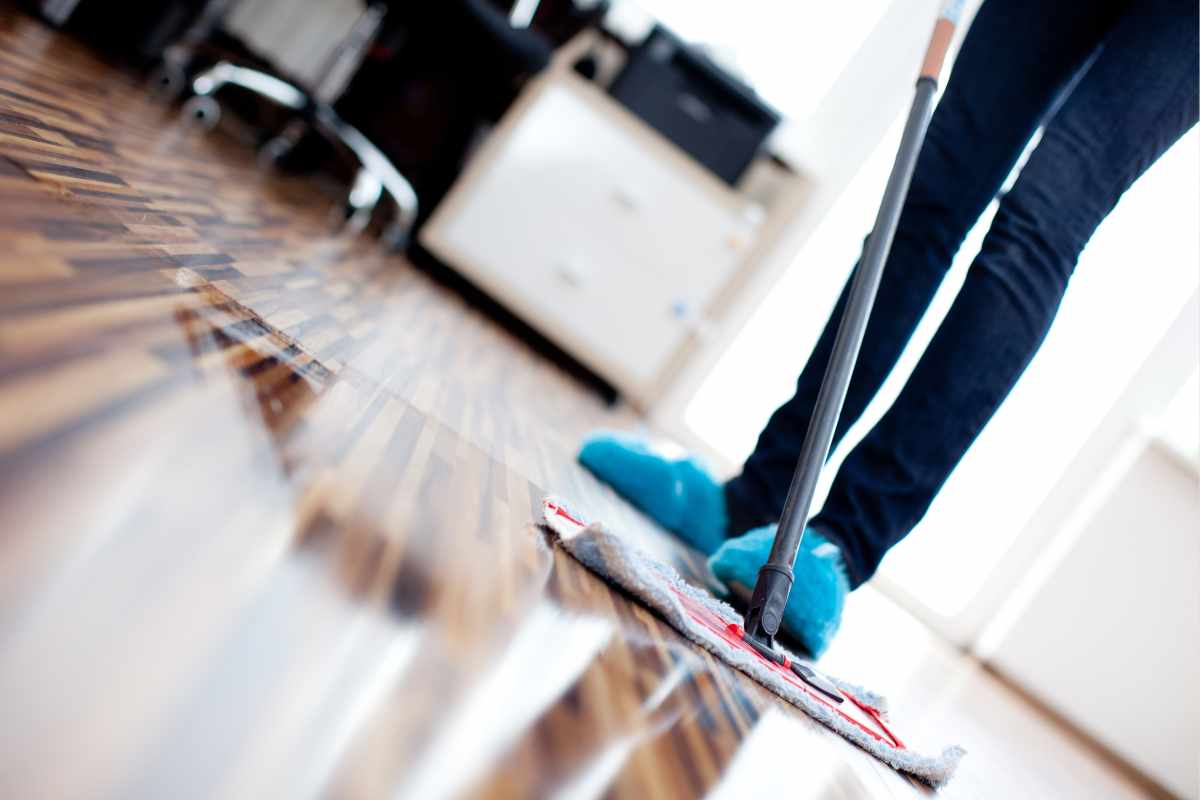 donna pulisce il pavimento in legno