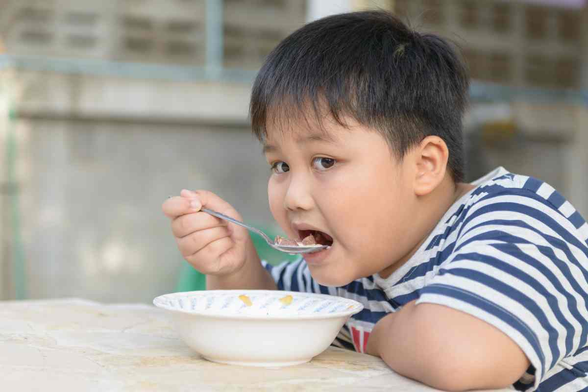 bambino mangia cereali dalla tazza