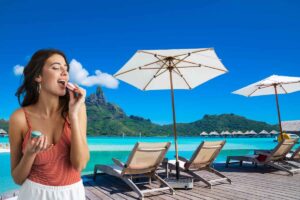 Una ragazza che mangia vicino ombrelloni e lettini che affacciano sul mare