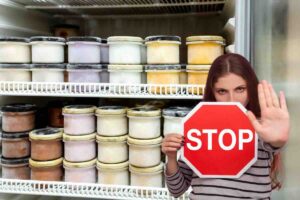 frigo con gelati e donna con segnale stop