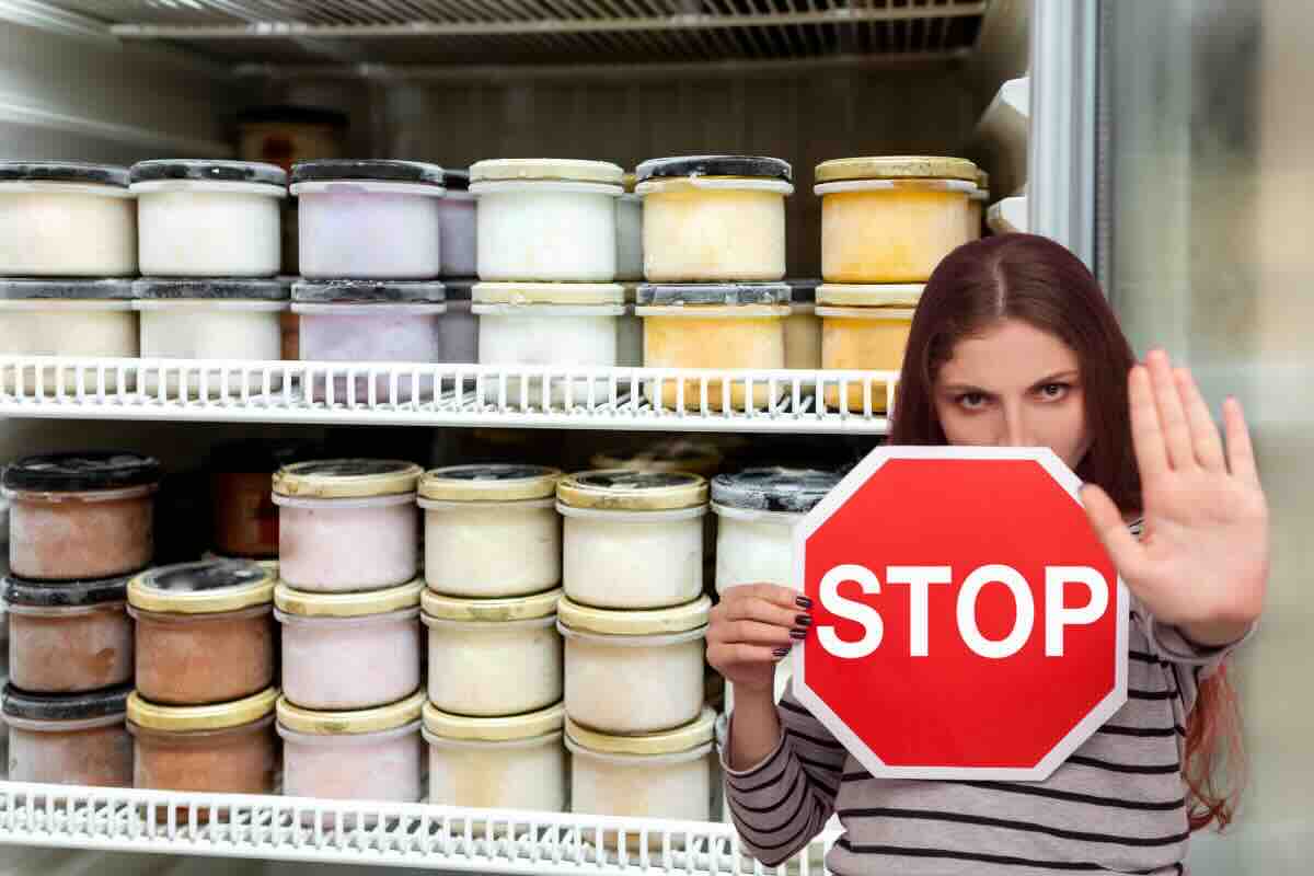 frigo con gelati e donna con segnale stop
