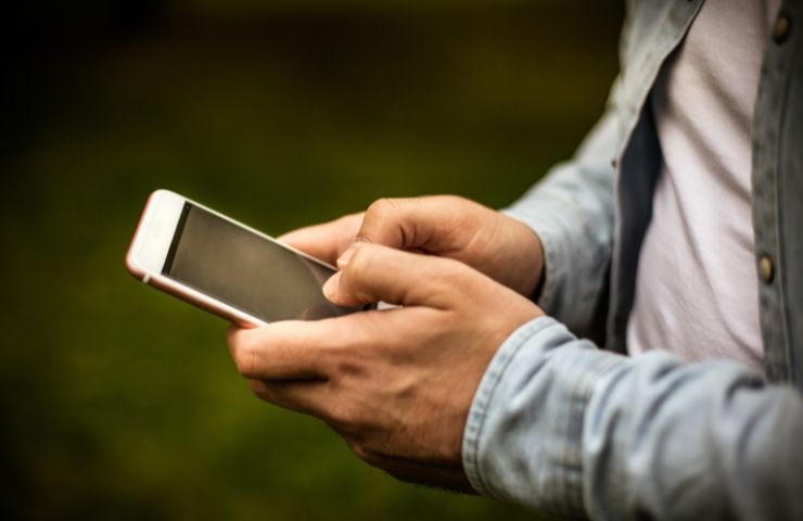 una persona che tiene il cellulare in mano
