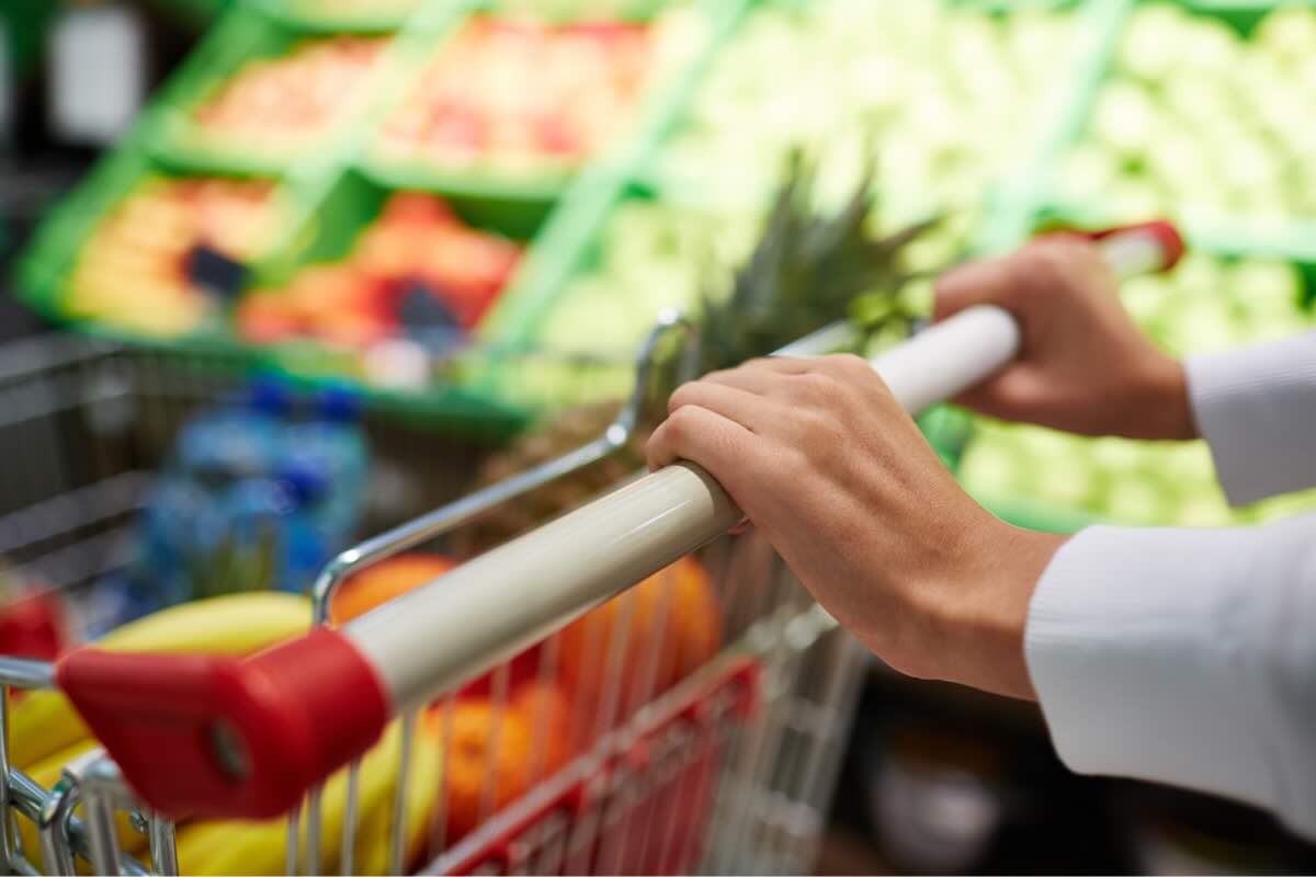 mani su carrello spesa supermercato