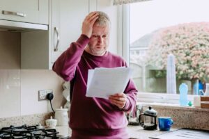 una persona che legge un foglio e si dispera