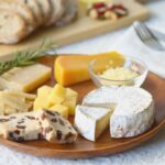 tagliere di formaggi e accanto delle fette di pane