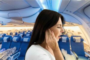 Posti a sedere in aereo, donna che si tocca orecchio sofferente