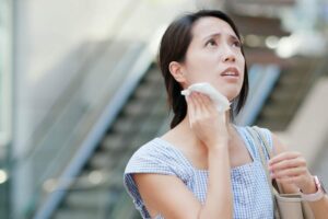 Donna si asciuga sudore con fazzoletto