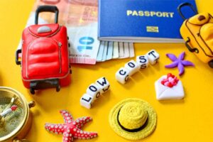 una valigia, dei soldi, un passaporto e la scritta viaggi low cost