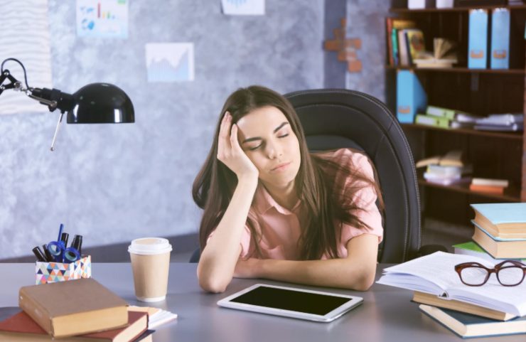 donna che dorme seduta alla scrivania